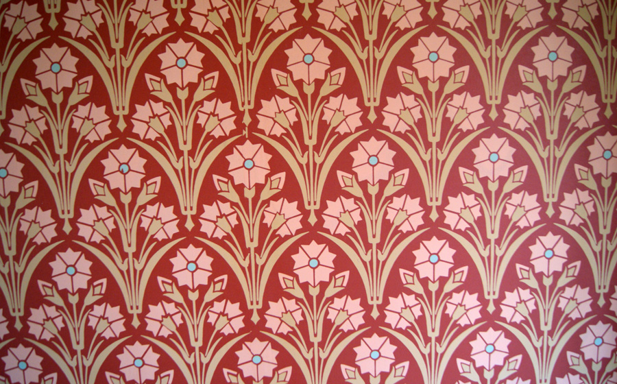 Detail of Arts & Crafts wallpaper — red ground with cream and pink stylized floral pattern in the William Morris tradition