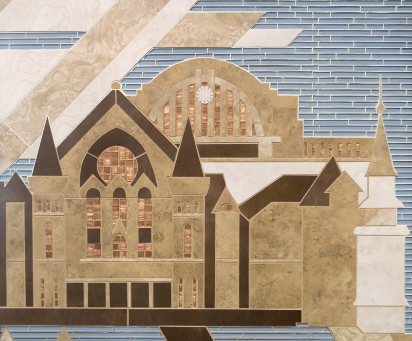 Detail of mosaic mural showing a Cincinnati landmark building's Gothic facade in tan and dark brown tile, arched windows with copper-mosaic inlays, set against horizontal blue glass mosaic