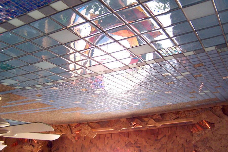 Light reflecting off blue and white iridescent glass mosaic tile across a panelled ceiling