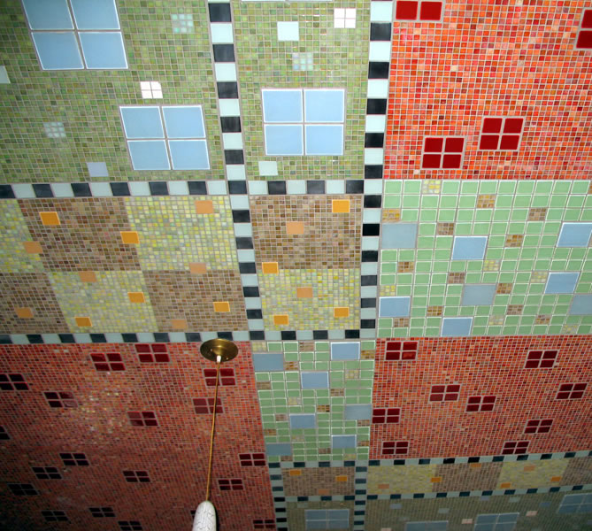 Mosaic-tiled ceiling quadrants in olive, brown, red, and green iridescent glass tile with checkered borders and a brass pendant lamp